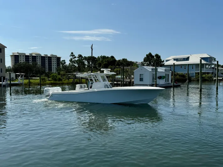  Yacht Photos Pics 2023 Invincible 36 Open Fisherman boat on calm water near docks.