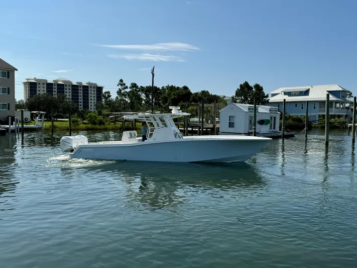  Yacht Photos Pics 2023 Invincible 36 Open Fisherman boat on calm water near docks.