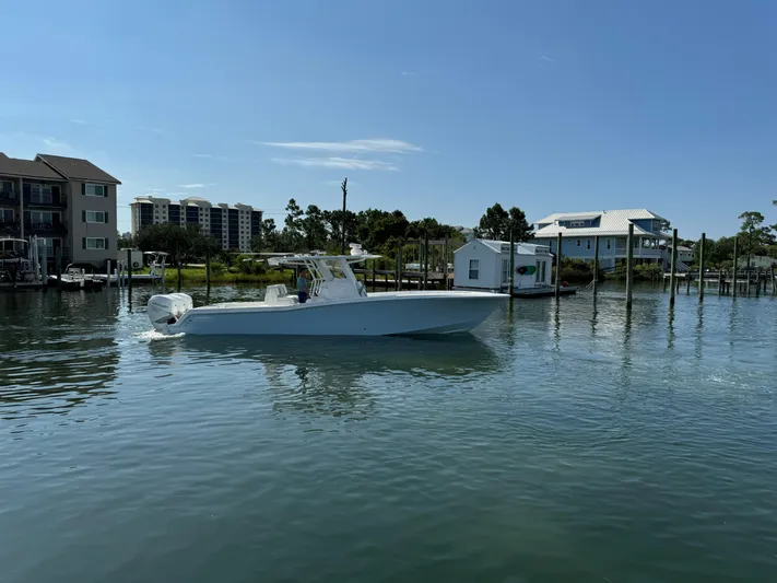  Yacht Photos Pics 2023 Invincible 36 Open Fisherman boat on calm water near docks.