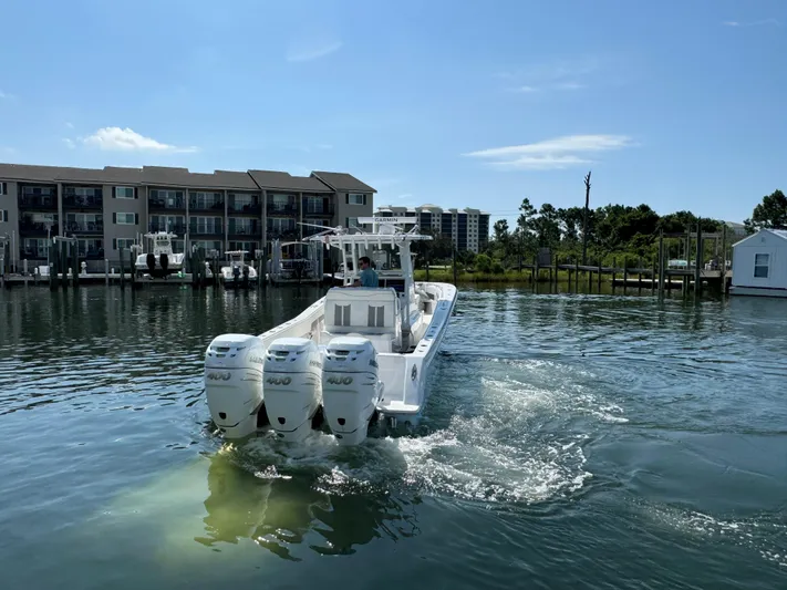  Yacht Photos Pics 2023 Invincible 36 Open Fisherman boat with triple engines on a calm waterway.