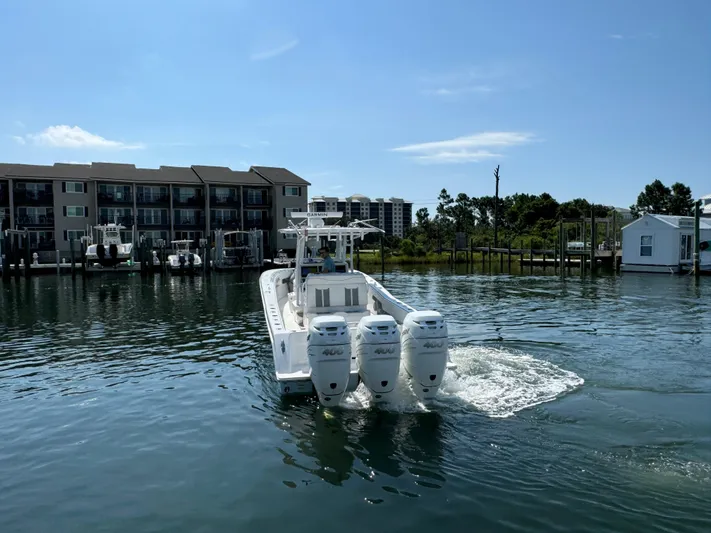  Yacht Photos Pics 2023 Invincible 36 Open Fisherman boat with triple engines on a calm waterfront.