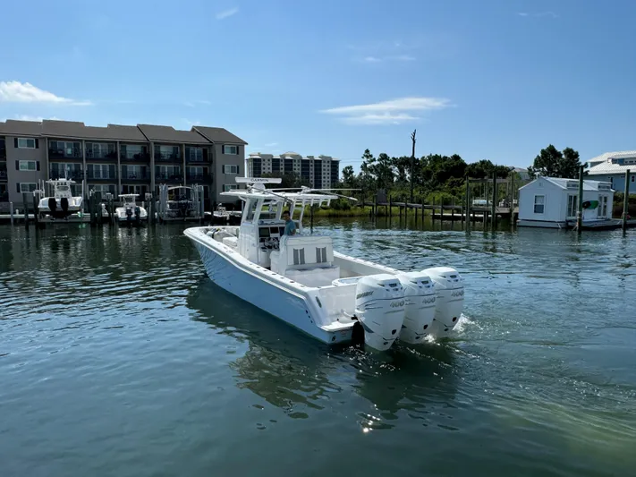  Yacht Photos Pics 2023 Invincible 36 Open Fisherman boat on calm water near docks.