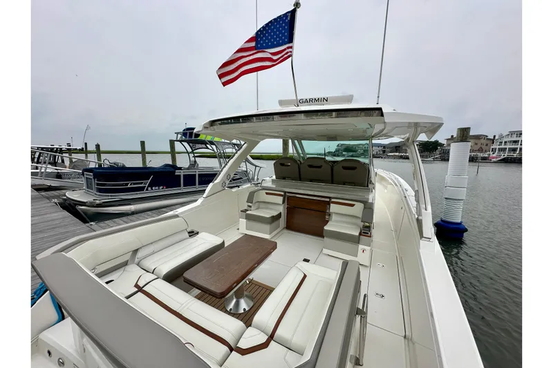  Yacht Photos Pics 2022 Tiara Yachts 38 LS at dock, featuring spacious seating and American flag.