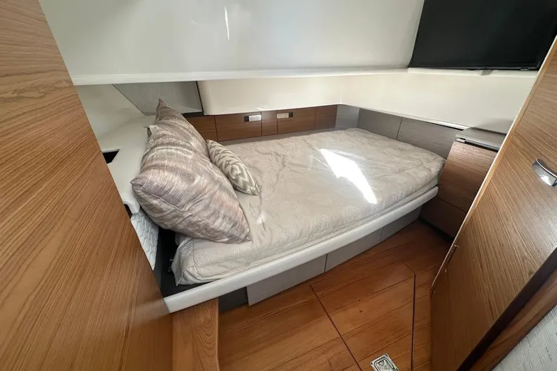  Yacht Photos Pics Luxurious cabin interior of 2022 Tiara Yachts 38 LS with cozy bedding and wooden accents.