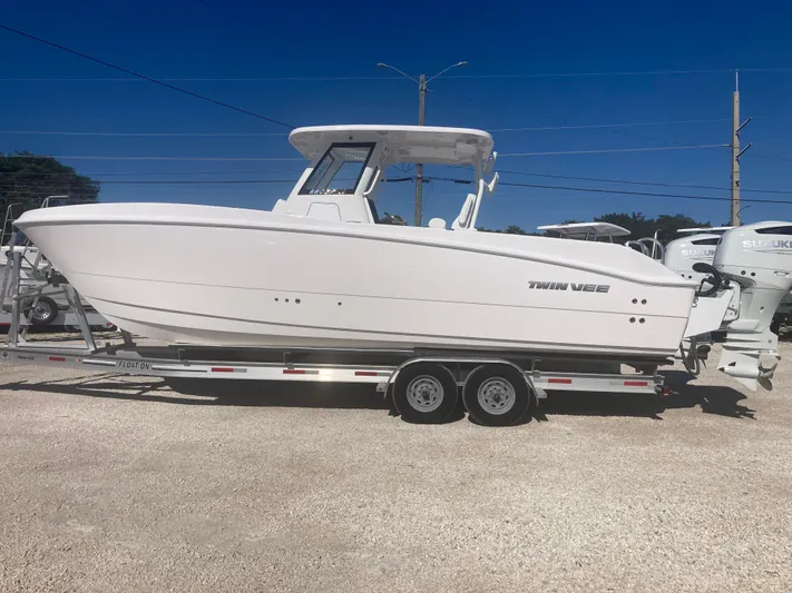  Yacht Photos Pics 2025 Twin Vee 280GFX2 boat on trailer in sunny outdoor setting.