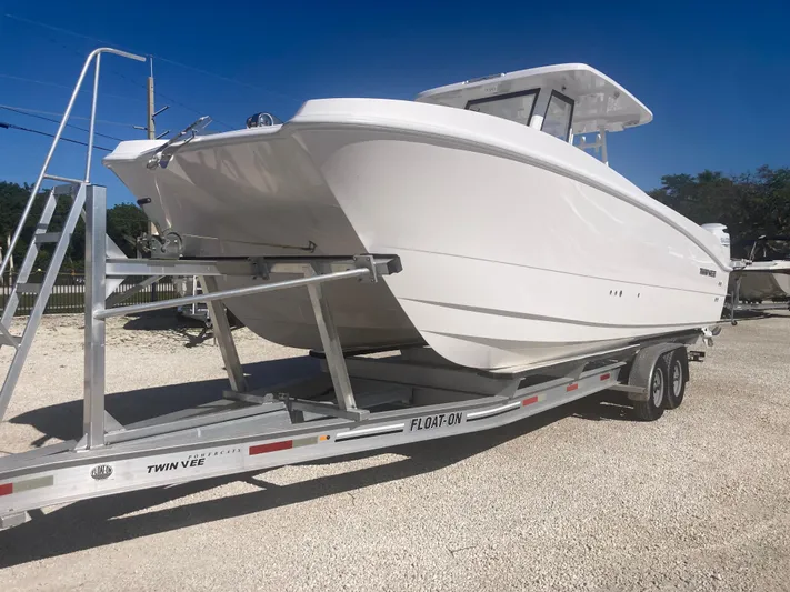  Yacht Photos Pics 2025 Twin Vee 280GFX2 boat on trailer, parked outdoors under clear blue sky.
