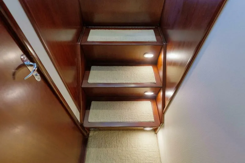 Salemwolf Yacht Photos Pics Wooden staircase with carpeted steps and lighting in a 2000 Garlington 61 C yacht.
