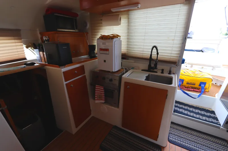  Yacht Photos Pics Interior of 2001 Lagoon 380 catamaran kitchen with appliances and wooden cabinetry.