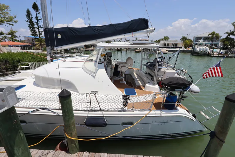  Yacht Photos Pics 2001 Lagoon 380 catamaran docked in a marina, featuring a sleek design and American flag.