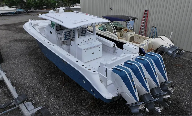  Yacht Photos Pics 2025 HCB 42 Lujo boat with four powerful outboard engines, docked outdoors.