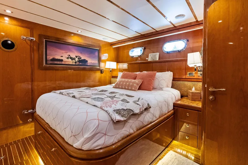 Tortuga Yacht Photos Pics Luxurious bedroom interior of 1999 Monte Fino 82 yacht with elegant wood paneling.