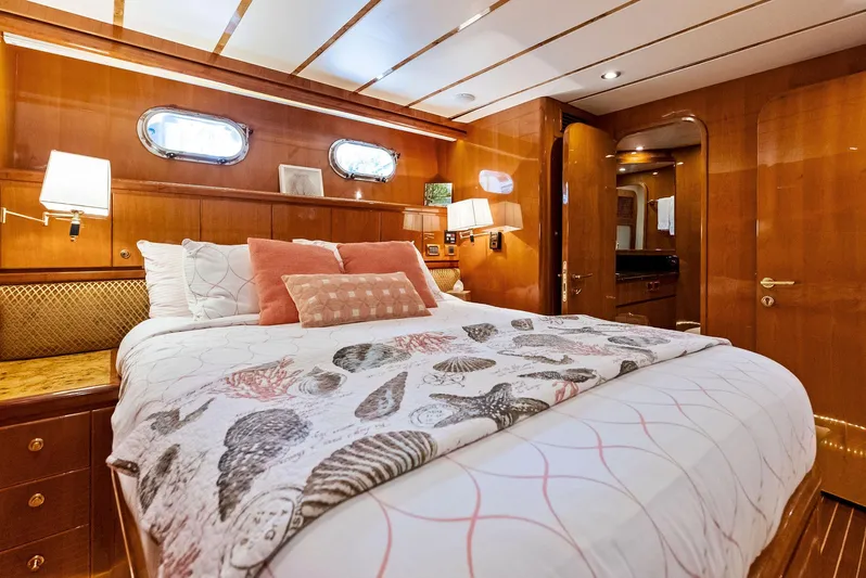 Tortuga Yacht Photos Pics Luxurious bedroom interior of 1999 Monte Fino 82 yacht with elegant wood paneling.