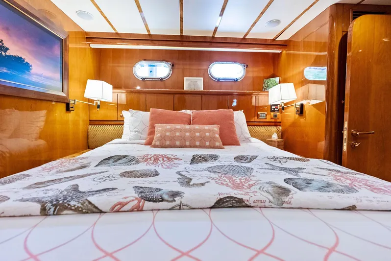 Tortuga Yacht Photos Pics Luxurious bedroom interior of 1999 Monte Fino 82 yacht with elegant bedding and warm lighting.