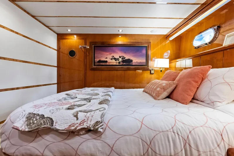 Tortuga Yacht Photos Pics Luxurious Monte Fino 82 yacht bedroom, 1999 model, with elegant wood paneling and cozy bedding.