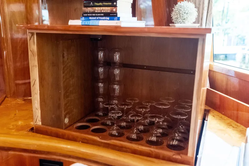 Tortuga Yacht Photos Pics Wooden cabinet with glassware and books on a 1999 Monte Fino 82 yacht.