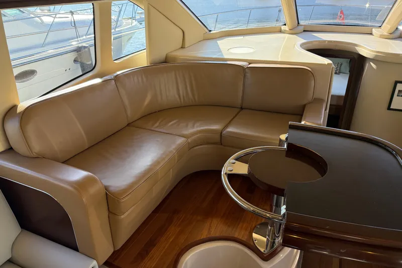  Yacht Photos Pics Luxurious interior of 2006 Sea Ray 44 Sedan Bridge with leather seating and wooden accents.