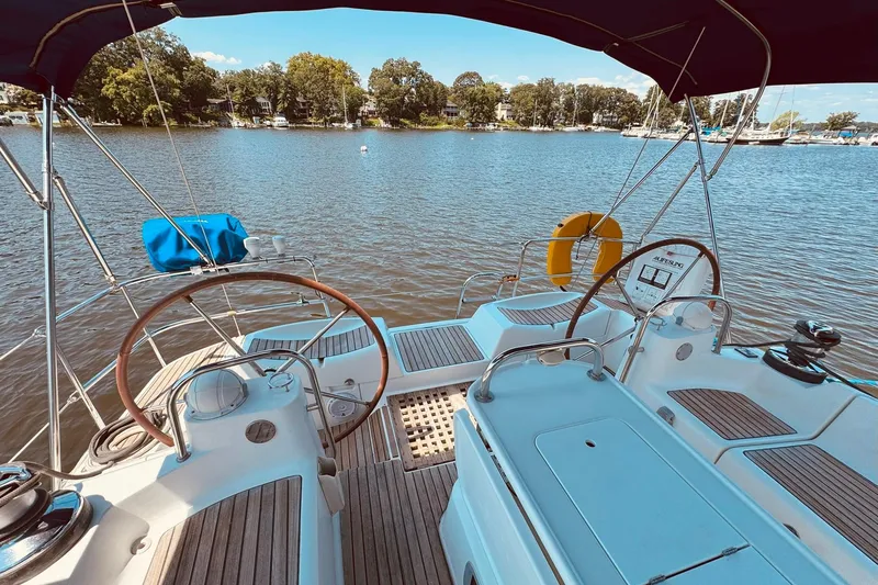 Bluefin Yacht Photos Pics Cockpit view of 2008 Jeanneau Sun Odyssey 45 DS sailboat on a serene lake.