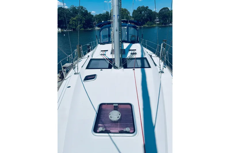 Bluefin Yacht Photos Pics 2008 Jeanneau Sun Odyssey 45 DS sailboat deck with blue canopy, docked by a lake.