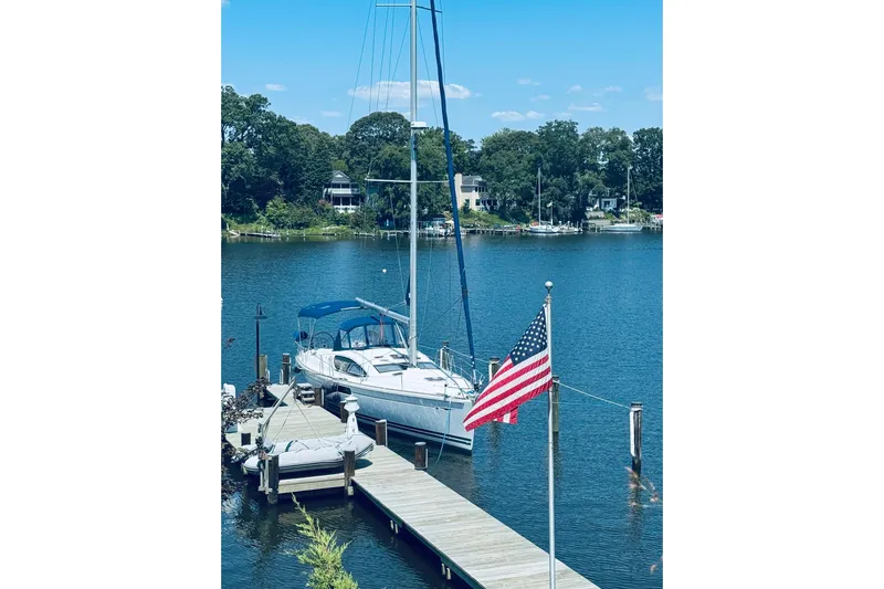 Bluefin Yacht Photos Pics Jeanneau Sun Odyssey 45 DS sailboat docked by a lake with American flag, 2008 model.