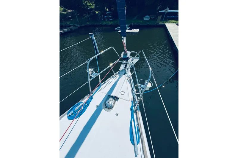 Bluefin Yacht Photos Pics Bow view of 2008 Jeanneau Sun Odyssey 45 DS sailboat docked in calm waters.