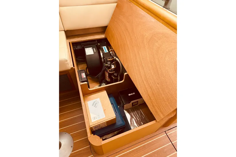Bluefin Yacht Photos Pics Storage compartment in 2008 Jeanneau Sun Odyssey 45 DS yacht, showcasing equipment and wooden finish.