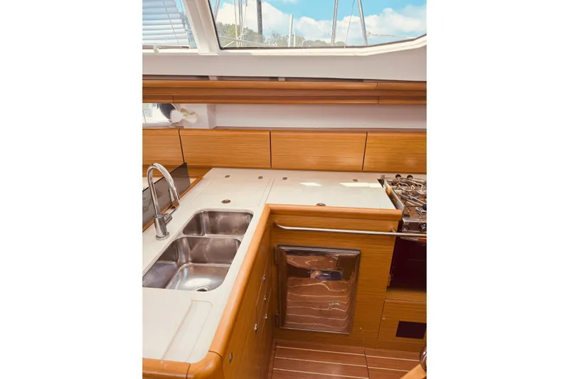 Bluefin Yacht Photos Pics Interior of 2008 Jeanneau Sun Odyssey 45 DS yacht kitchen with wood finish and stainless steel sink.