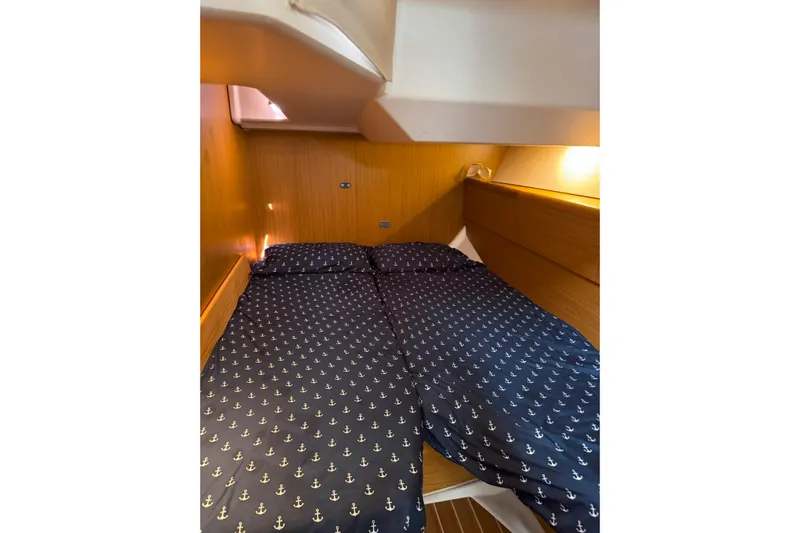 Bluefin Yacht Photos Pics Cozy cabin interior of 2008 Jeanneau Sun Odyssey 45 DS with anchor-patterned bedding.