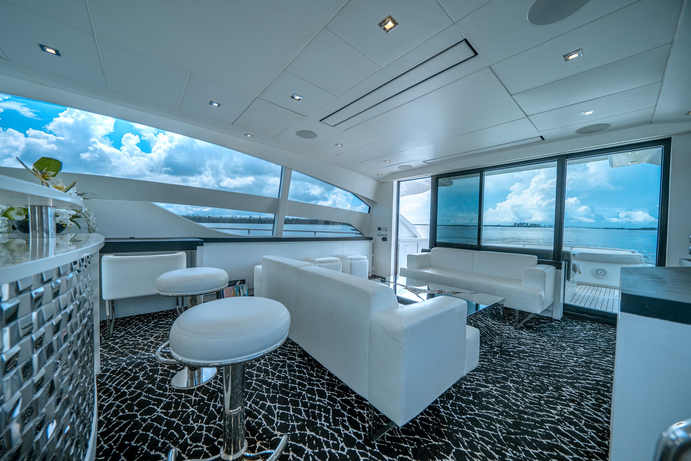 Luxurious interior of 2010 Pershing 80 yacht with modern white seating and ocean view.