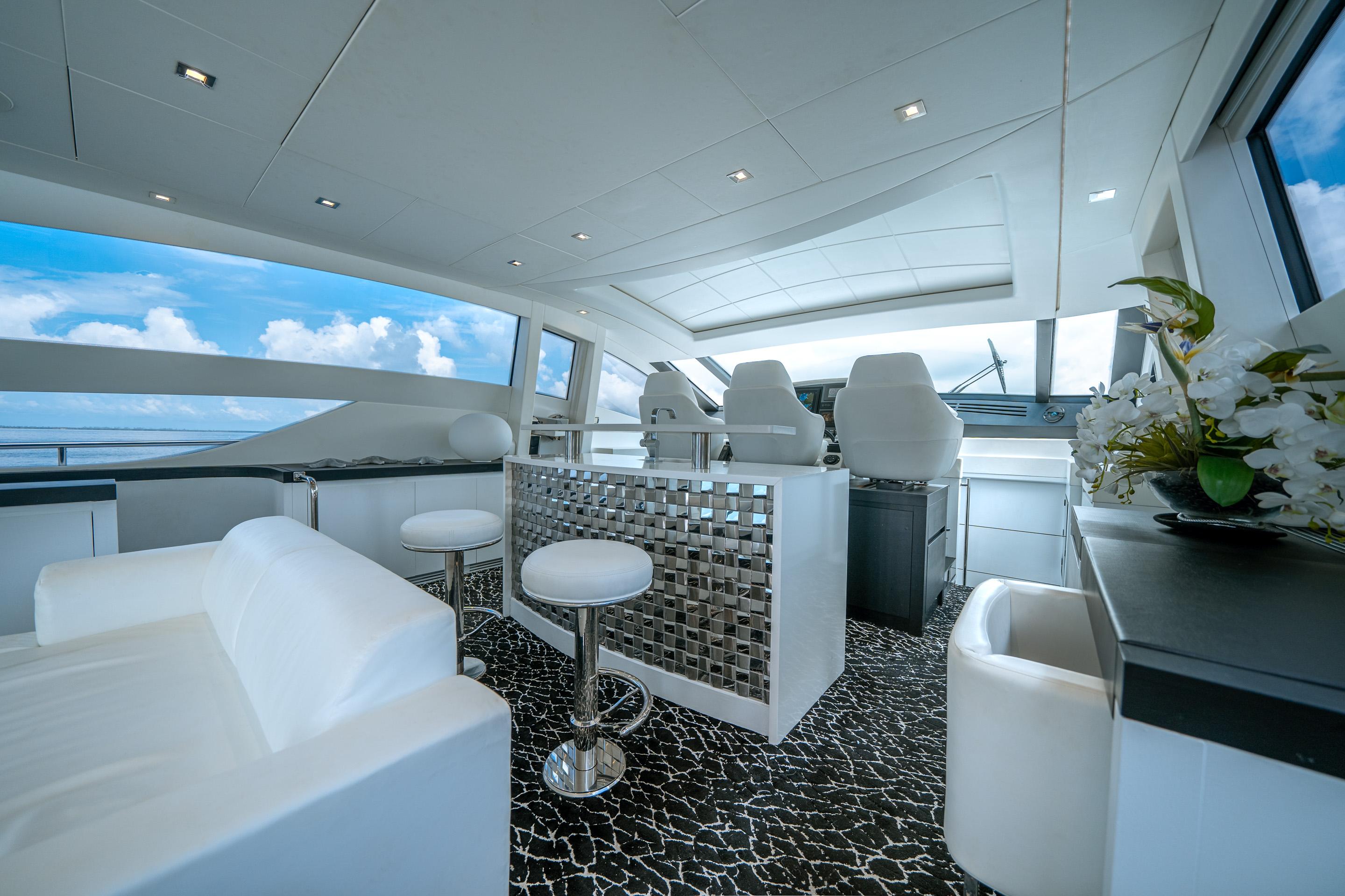 Luxurious interior of 2010 Pershing 80 yacht with modern seating and panoramic windows.