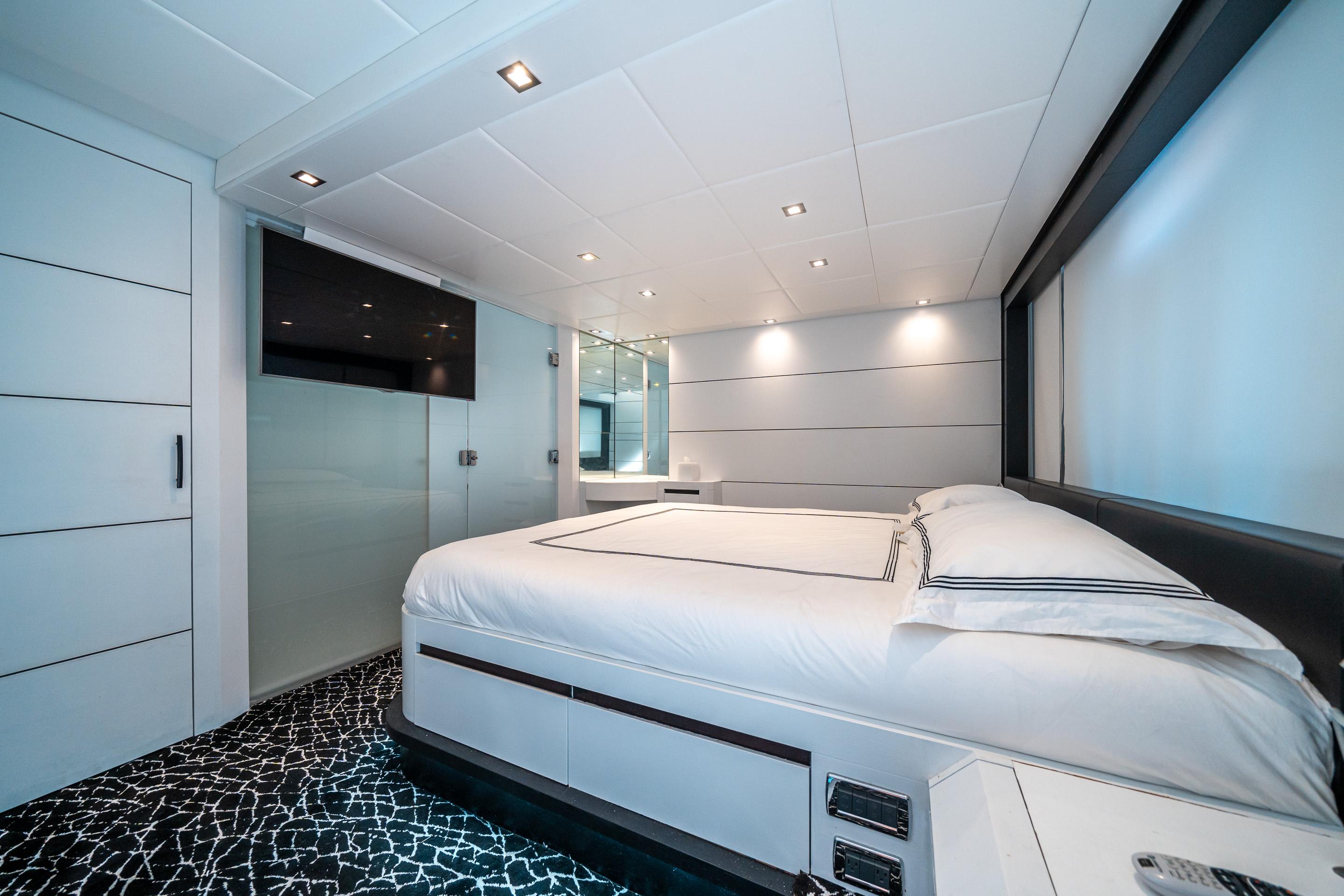 Luxurious bedroom interior on a 2010 Pershing 80 yacht, featuring modern design and elegant lighting.