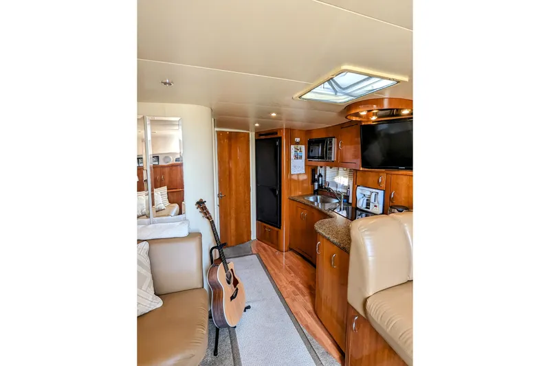  Yacht Photos Pics Interior of 2004 Carver 360 Mariner yacht with kitchen, seating, and guitar.