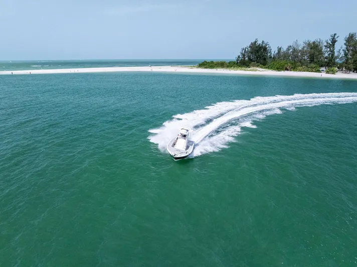  Yacht Photos Pics 2018 Barker Boatworks 26 Calibogue Bay cruising near a sandy shoreline.