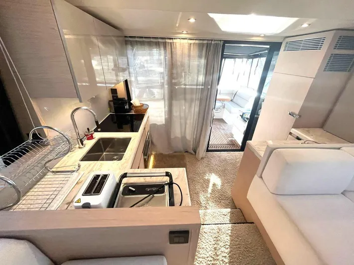 Rialtin Yacht Photos Pics Luxurious interior of 2022 Beneteau Monte Carlo 52 yacht with modern kitchen and seating area.