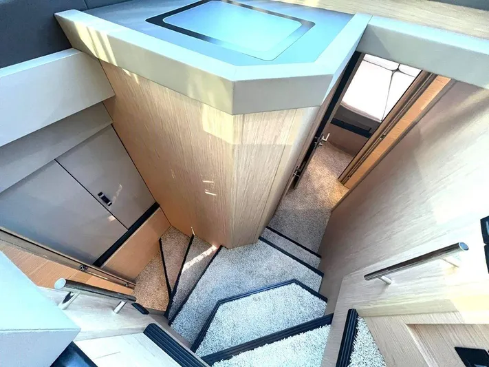 Rialtin Yacht Photos Pics Modern interior staircase of 2022 Beneteau Monte Carlo 52 yacht, featuring sleek design and wood finishes.