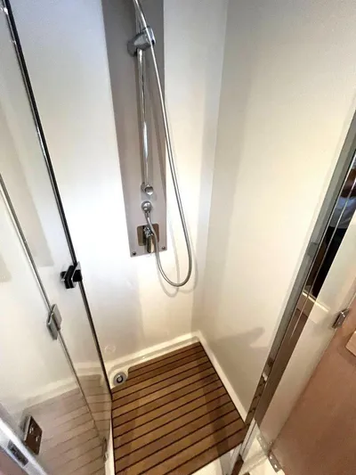 Rialtin Yacht Photos Pics Shower area in 2022 Beneteau Monte Carlo 52 yacht with wooden floor and glass door.