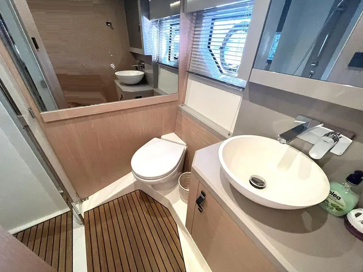 Rialtin Yacht Photos Pics Luxurious bathroom in 2022 Beneteau Monte Carlo 52 yacht with modern fixtures and wooden flooring.