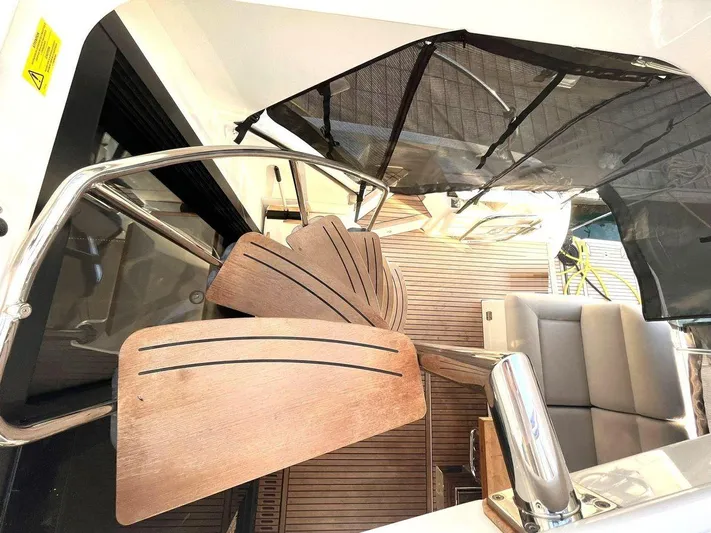 Rialtin Yacht Photos Pics Spiral staircase on 2022 Beneteau Monte Carlo 52 yacht with wooden steps and sleek design.