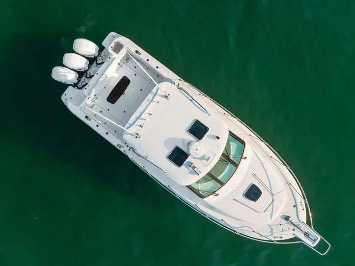 Giddy Up Yacht Photos Pics Aerial view of 2009 Boston Whaler 345 Conquest boat on green water.