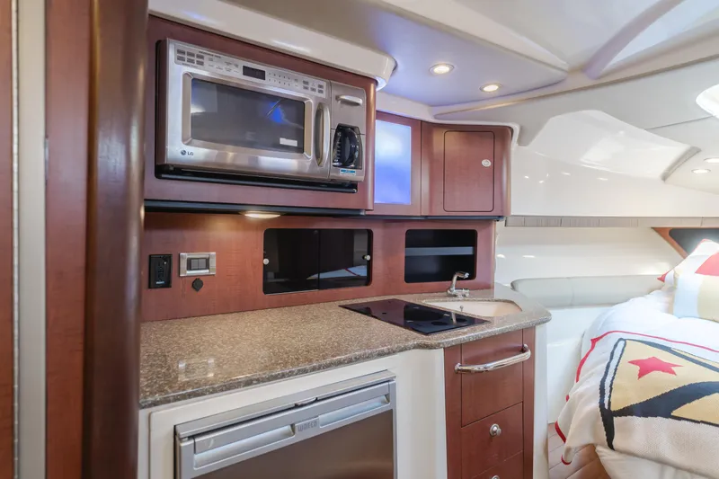 Giddy Up Yacht Photos Pics 2009 Boston Whaler 345 Conquest cabin kitchen with microwave, sink, and storage.
