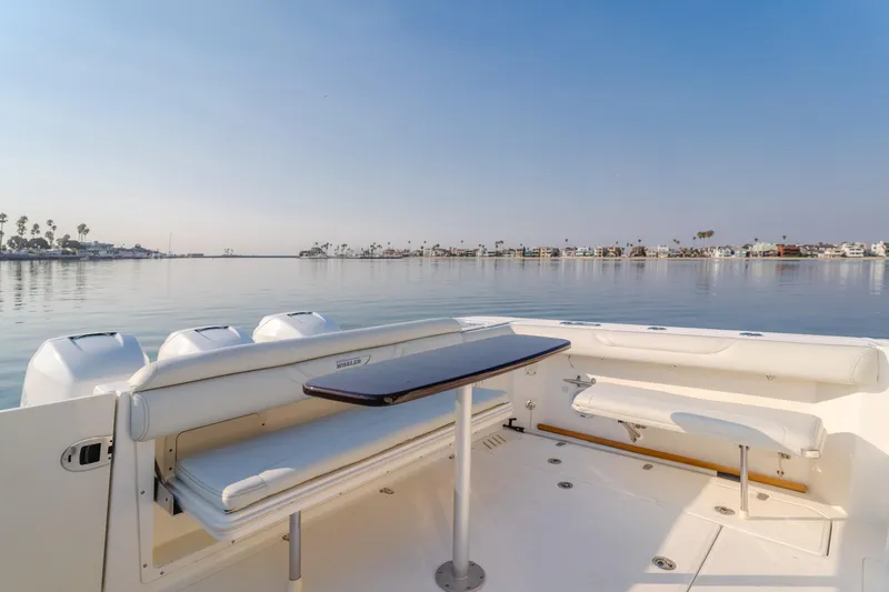 Giddy Up Yacht Photos Pics 2009 Boston Whaler 345 Conquest boat interior with seating and table, calm waters in background.