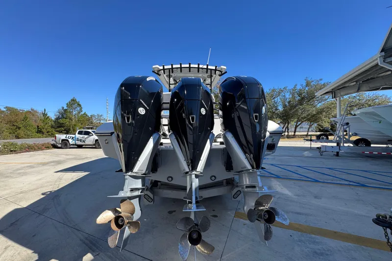  Yacht Photos Pics 2023 Fountain 34 Tournament Edition boat with triple outboard engines, docked under clear blue sky.
