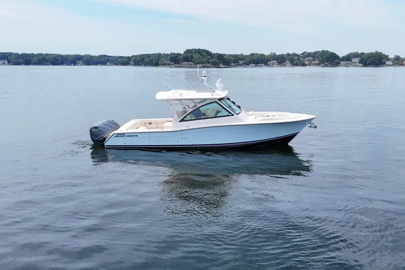  Yacht Photos Pics 2023 Grady-White Freedom 375 boat on calm lake waters, showcasing sleek design.