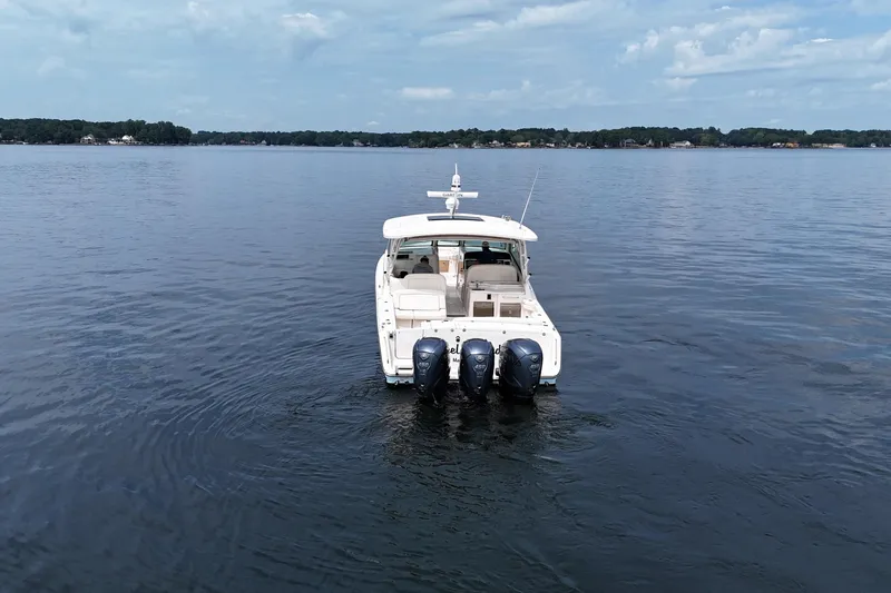  Yacht Photos Pics 2023 Grady-White Freedom 375 boat on calm lake under blue sky.