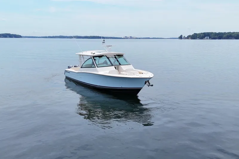  Yacht Photos Pics 2023 Grady-White Freedom 375 boat on calm water, clear sky background.