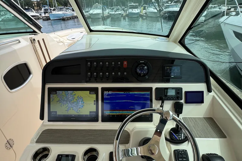  Yacht Photos Pics 2023 Grady-White Freedom 375 helm with navigation screens and steering wheel, docked at marina.