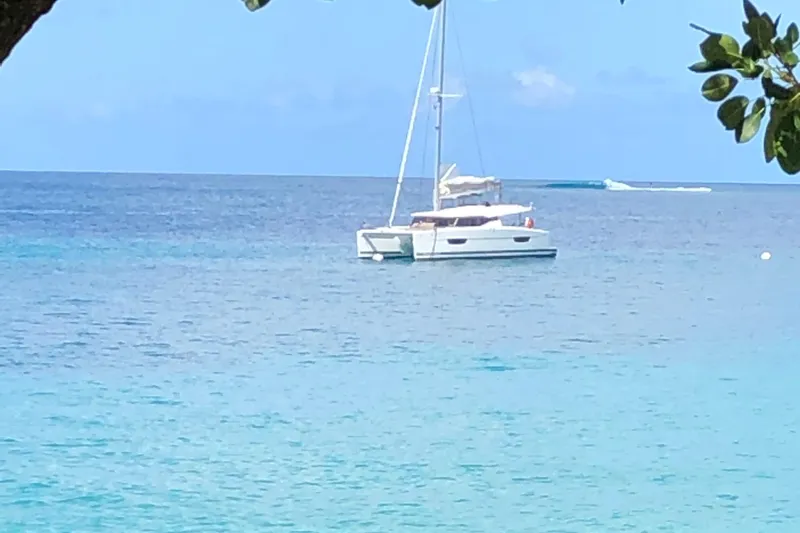 Sabai Sabai Yacht Photos Pics 2018 Fountaine Pajot Lucia 40 catamaran anchored in tranquil blue waters.