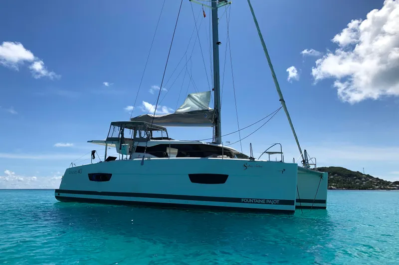 Sabai Sabai Yacht Photos Pics 2018 Fountaine Pajot Lucia 40 catamaran sailing on clear turquoise waters.