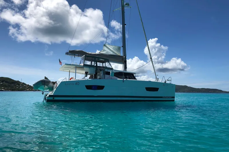 Sabai Sabai Yacht Photos Pics 2018 Fountaine Pajot Lucia 40 catamaran sailing on clear turquoise waters.