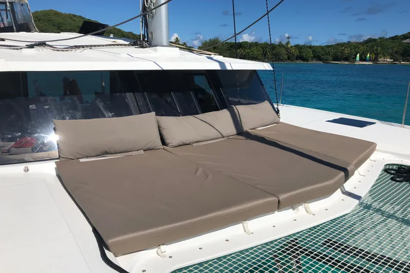 Sabai Sabai Yacht Photos Pics Fountaine Pajot Lucia 40 catamaran with sunbathing cushions, anchored near a tropical island, 2018 model.