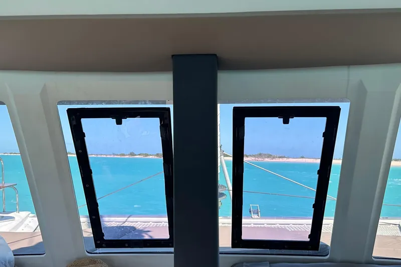 Sabai Sabai Yacht Photos Pics View from inside a 2018 Fountaine Pajot Lucia 40, overlooking turquoise waters and distant shoreline.